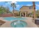 Backyard showcasing a refreshing pool and spa, complemented by a covered patio and mature trees at 2445 Rue Royale, Henderson, NV 89044