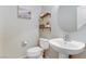 Neutral powder room with round mirror, decorative shelves, and pedestal sink at 2445 Rue Royale, Henderson, NV 89044