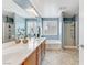 Bright bathroom featuring a double sink vanity, a soaking tub and a glass-enclosed shower at 2445 Rue Royale, Henderson, NV 89044