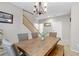 The dining room features a wooden table with chairs, a chandelier, and a staircase leading to the upper level at 2445 Rue Royale, Henderson, NV 89044