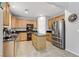 Modern kitchen featuring stainless steel appliances, granite countertops, and an island with a black countertop at 2445 Rue Royale, Henderson, NV 89044
