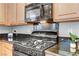 Kitchen features sleek black gas range and microwave oven with granite countertops and ample cabinet storage at 2445 Rue Royale, Henderson, NV 89044
