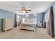 Bright main bedroom features a ceiling fan, two windows with shutters and beautiful blue walls at 2445 Rue Royale, Henderson, NV 89044