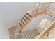 Carpeted stairs with wooden railing lead to lower level with tile flooring at 2445 Rue Royale, Henderson, NV 89044