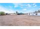 The flat backyard has metal fences under a blue sky and distant home at 266 Tungsten St, Henderson, NV 89015