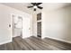 Cozy bedroom with a ceiling fan, gray wood floors, and a closet leading into the kitchen at 266 Tungsten St, Henderson, NV 89015