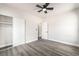 This light and airy bedroom includes gray wood floors, a ceiling fan, and sliding closet doors at 266 Tungsten St, Henderson, NV 89015
