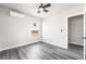 Bright bedroom featuring gray wood floors, a ceiling fan, and a large window at 266 Tungsten St, Henderson, NV 89015