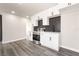 Modern kitchen with white cabinets, stainless steel appliances, dark backsplash, and gray hardwood flooring at 266 Tungsten St, Henderson, NV 89015