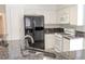 Contemporary kitchen with granite countertops, black refrigerator, and a double basin sink at 2753 Devita Cir, Las Vegas, NV 89117