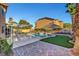 Beautiful backyard features a sparkling pool, putting green, covered patio, and lush landscaping at 281 Powerbilt Ave, Las Vegas, NV 89148