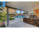 Outdoor kitchen with a stone facade near the pool and yard at 281 Powerbilt Ave, Las Vegas, NV 89148