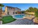 Expansive backyard with swimming pool, putting green, well-manicured lawn, and a spacious patio area at 281 Powerbilt Ave, Las Vegas, NV 89148