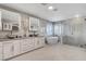 Stunning bathroom with dual sinks, a soaking tub, and a separate glass-enclosed shower with beautiful tile work at 281 Powerbilt Ave, Las Vegas, NV 89148