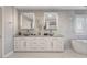 Bright bathroom with dual vessel sinks, LED mirrors, and a soaking tub for a spa-like experience at 281 Powerbilt Ave, Las Vegas, NV 89148