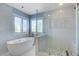 Modern bathroom featuring a soaking tub, walk-in shower with pebble floor, and natural light at 281 Powerbilt Ave, Las Vegas, NV 89148