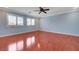 Spacious bedroom featuring hardwood floors, two windows, and a ceiling fan at 281 Powerbilt Ave, Las Vegas, NV 89148