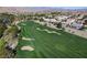Elevated view of a lush golf course, with sand traps, meticulously maintained greens and homes nearby at 281 Powerbilt Ave, Las Vegas, NV 89148