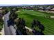 Overhead view of a verdant golf course lined by trees, with manicured greens and residential area in the distance at 281 Powerbilt Ave, Las Vegas, NV 89148