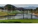Scenic golf course features a pond, sprinklers, mountain views, and palm trees at 281 Powerbilt Ave, Las Vegas, NV 89148