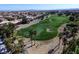 Scenic aerial shot of a golf course featuring sand traps, palm trees, and manicured lawns in a residential area at 281 Powerbilt Ave, Las Vegas, NV 89148