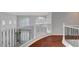 Second story hallway with dark wood floors, decorative wrought iron railing, and natural light at 281 Powerbilt Ave, Las Vegas, NV 89148