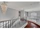 Bright upstairs hallway with decorative wrought iron railing, dark wood floors, and elegant chandelier at 281 Powerbilt Ave, Las Vegas, NV 89148