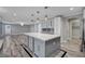 Island kitchen with white marble counters, gray cabinets, stainless appliances, and wood-look floors at 281 Powerbilt Ave, Las Vegas, NV 89148