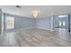 Large open living area with wood-look tile flooring, elegant chandelier, and lots of light at 281 Powerbilt Ave, Las Vegas, NV 89148