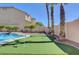 Manicured putting green and backyard with beautiful tropical trees at 281 Powerbilt Ave, Las Vegas, NV 89148