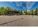 Sandy community volleyball court surrounded by lush green trees and beautiful residential homes at 281 Powerbilt Ave, Las Vegas, NV 89148