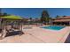 Community pool and spa featuring ample lounge chairs, covered seating, and manicured landscaping under a clear blue sky at 3151 Soaring Gulls Dr # 2081, Las Vegas, NV 89128