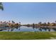 Scenic water view with waterfront homes, palm trees, clear sky, and manicured green lawn, reflecting peaceful ambiance at 3151 Soaring Gulls Dr # 2081, Las Vegas, NV 89128
