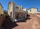 Spacious backyard with gravel, patio area, and a second story balcony, perfect for outdoor entertaining at 32 Focal Point Ave, North Las Vegas, NV 89031