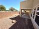 Low-maintenance backyard featuring gravel, a covered patio, and privacy wall, with plenty of room for outdoor enjoyment at 32 Focal Point Ave, North Las Vegas, NV 89031