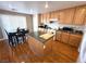 Bright kitchen with granite countertops, wooden cabinets, and an island, complete with modern appliances at 32 Focal Point Ave, North Las Vegas, NV 89031