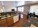 Kitchen with stainless steel sink, wooden cabinets, and laminate countertops open to the living and dining areas at 32 Focal Point Ave, North Las Vegas, NV 89031