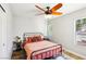 Cozy bedroom with a black iron bed frame, wood flooring, and natural light streaming through the windows at 3913 Ricebird Way, North Las Vegas, NV 89084