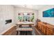 Inviting dining area with a wooden table, rustic bench, large windows, and hardwood floors at 3913 Ricebird Way, North Las Vegas, NV 89084