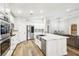 Bright kitchen features stainless steel appliances, white cabinets, and a large island with a sink and quartz countertop at 3913 Ricebird Way, North Las Vegas, NV 89084