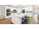 A kitchen features stainless steel appliances, white cabinets, a large island with a sink and quartz countertop, and stools at 3913 Ricebird Way, North Las Vegas, NV 89084