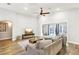 Bright living room with hardwood floors, ceiling fan, large couch, and sliding door access to the pool at 3913 Ricebird Way, North Las Vegas, NV 89084