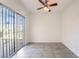 Bright bedroom features sliding glass door, ceiling fan, and neutral tile flooring at 3925 Torsby Pl, Las Vegas, NV 89119