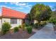 Inviting single-story home with a red tile roof, surrounded by lush landscaping at 3925 Torsby Pl, Las Vegas, NV 89119
