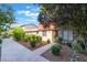 Charming townhome featuring a brick accent, mature landscaping, and a walkway leading to the front door at 3925 Torsby Pl, Las Vegas, NV 89119