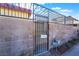 Front yard view with brick wall and black metal gate at 3925 Torsby Pl, Las Vegas, NV 89119