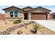 Inviting single-story house featuring desert landscaping, a neutral color palette, and a two-car garage enhances curb appeal at 3966 E Garfield Dr, Pahrump, NV 89061