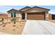Inviting single-story house featuring desert landscaping, a neutral color palette, and a two-car garage enhances curb appeal at 3966 E Garfield Dr, Pahrump, NV 89061