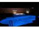 Nighttime view of a luminous pool with a fire feature, set against a decorative backyard wall at 3966 E Garfield Dr, Pahrump, NV 89061