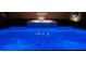 Inviting in-ground pool with a fire feature and soothing waterfall, beautifully lit at night at 3966 E Garfield Dr, Pahrump, NV 89061